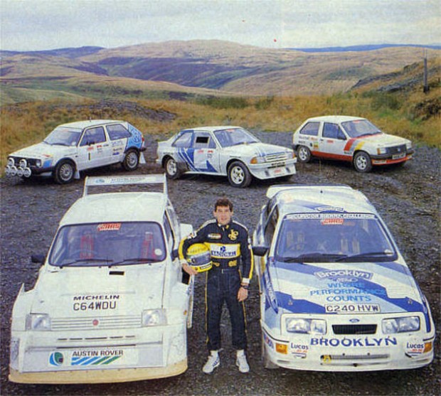 Senna in posa con le vetture che provò in Galles, nel 1986