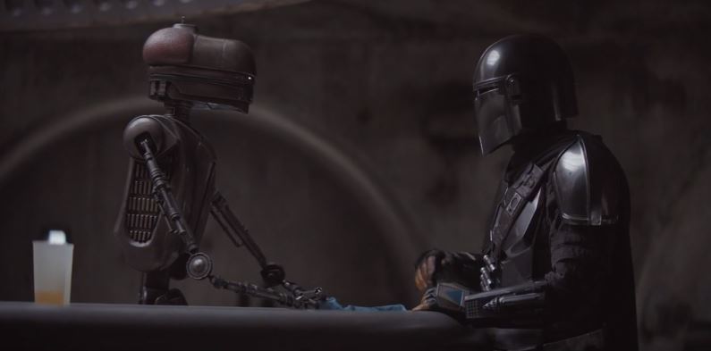 Mando parla con il droide al bancone della Cantina di Mos Eisley
