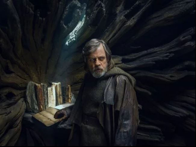 Luke Skywalker accanto ai tomi custoditi su Ahch-To