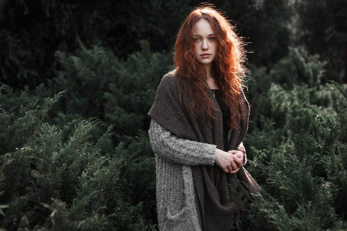 Il rapporto uomo natura in un legame eterno - woman in gray knit sweater standing near green plants during daytime