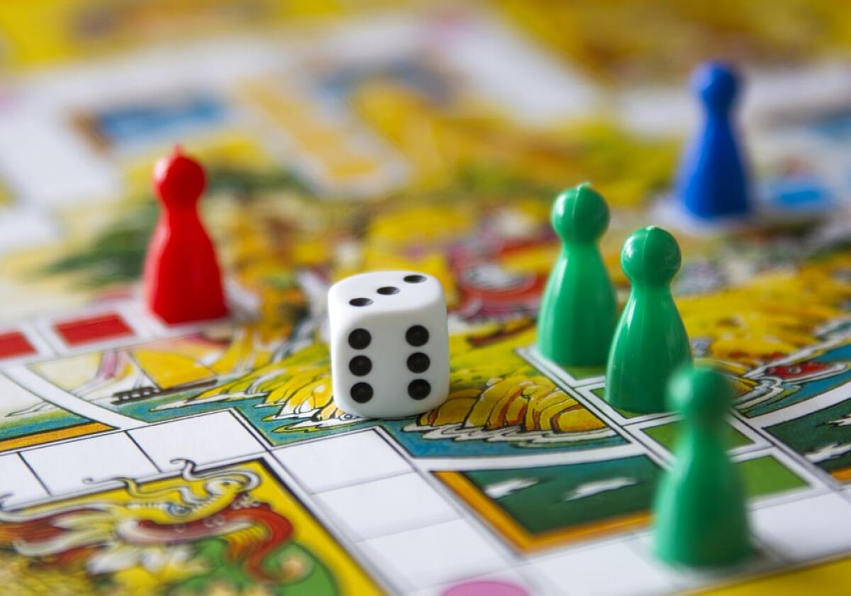 Giochi da tavolo: ecco i migliori e come sceglierli - colorful play figures with dice on board