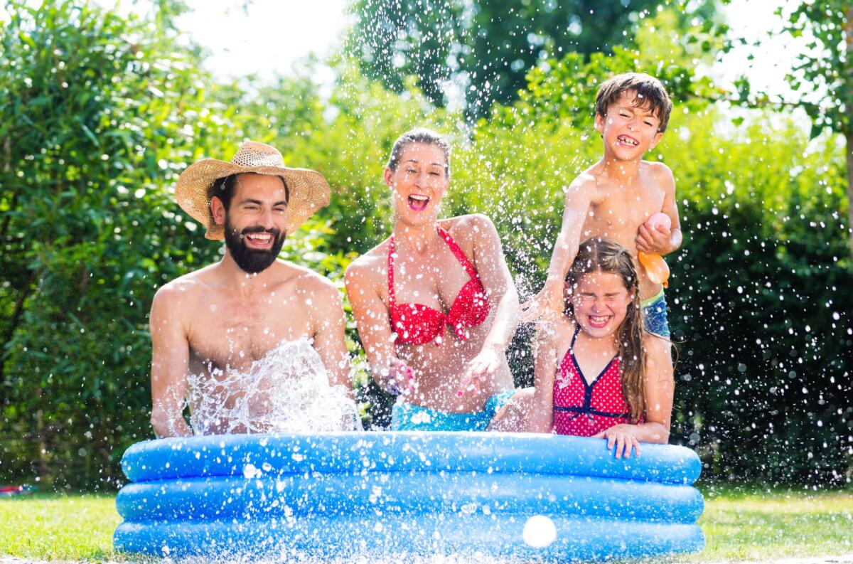 Piscina fuori terra gonfiabile: modelli e prezzi - Family in garden pool cooling down by splashing water
