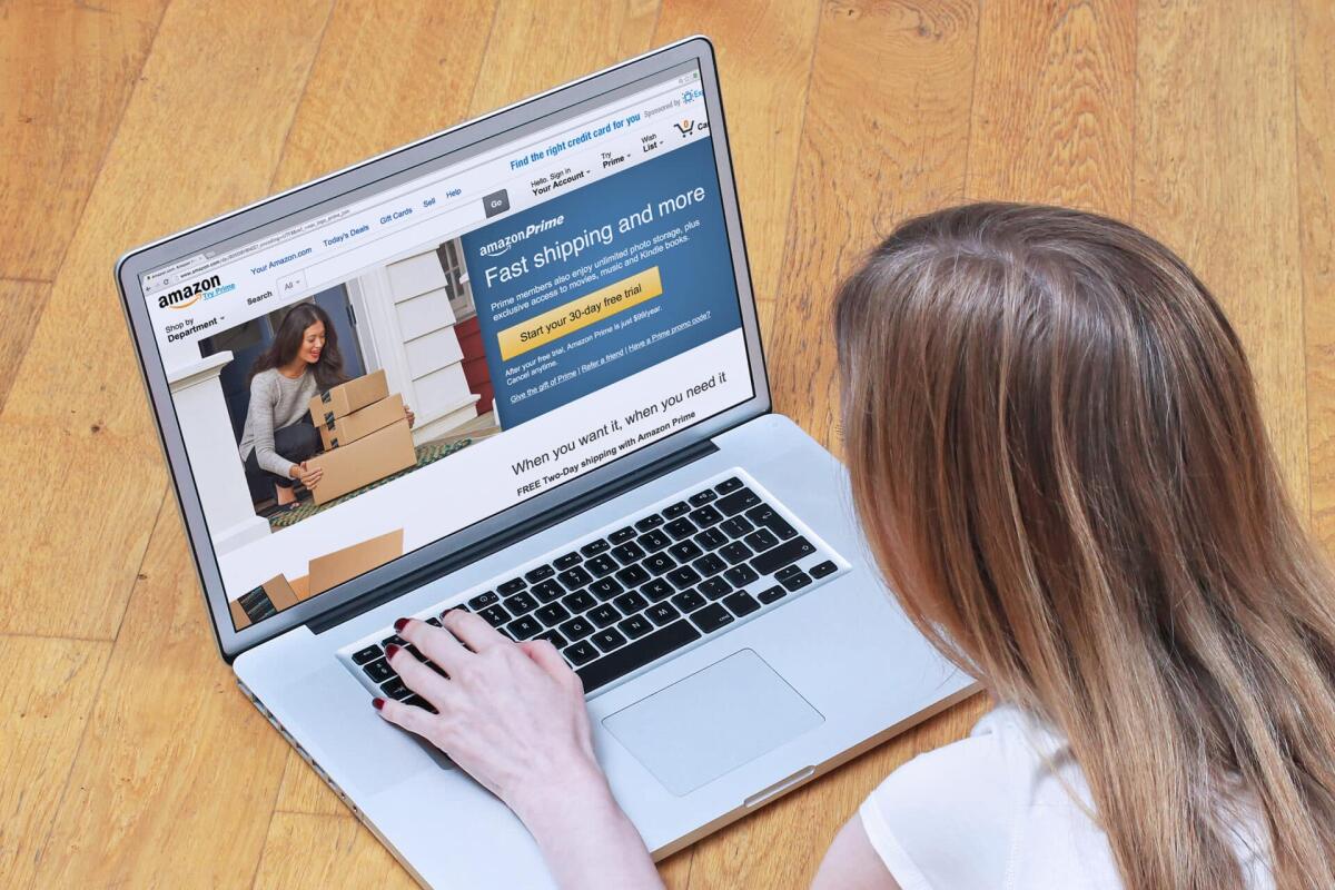 Come abbonarsi ad Amazon? - London, UK - February 06, 2015: Young woman signing up for Amazon Prime on online shopping site. Amazon Prime is paid service that gives Amazon shoppers free delivery and access to Prime Instant Video
