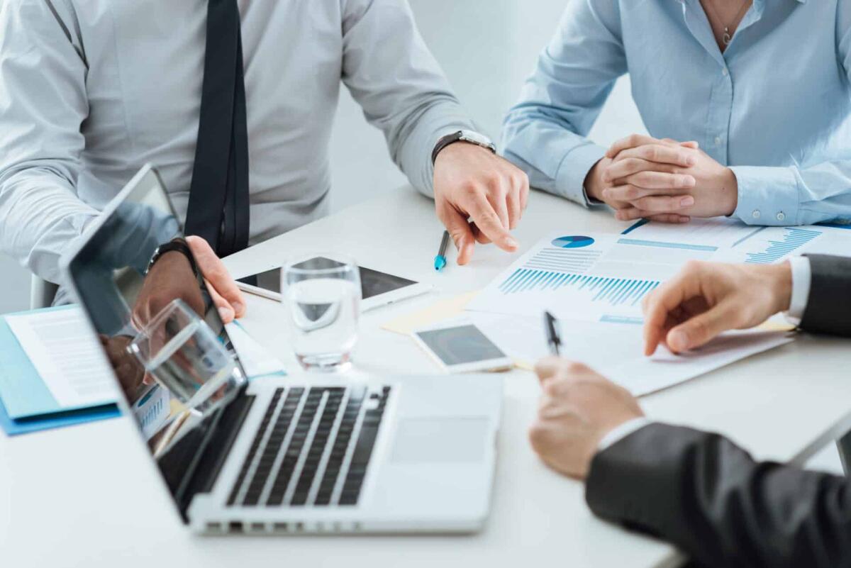 I servizi Fleeway e Fleerun di Drivevolve per la gestione delle flotte - Professional business team working together at office desk discussing during a meeting, efficiency and teamwork concept