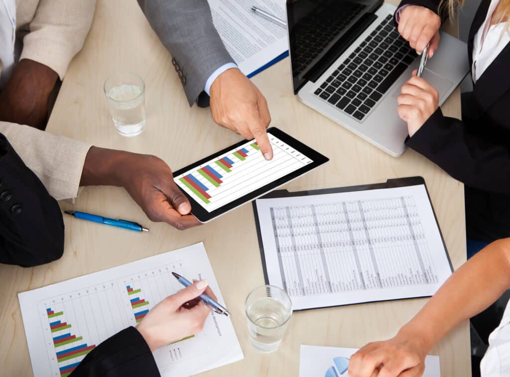 Multi Ethnic Business Colleagues Discussing Graph On Digital Tablet